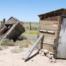 The old outhouses, with the abandoned Highway 24 grade beyond, World's Wonder View Tower, Genoa, CO. Old Outhouses, Worlds Wonderview Tower, Genoa, CO, Vince Pitelka